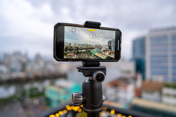 Close-up smartphone on tripod capturing night cityscape  timelapse. Mobile photography or videography concept.