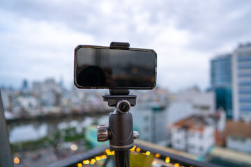 Close-up smartphone on tripod capturing night cityscape  timelapse. Mobile photography or videography concept.