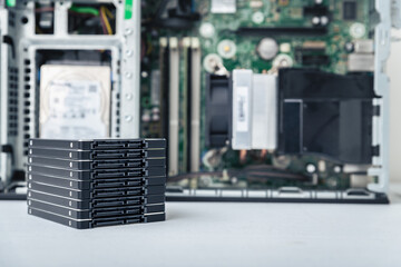 Closed-up view of SSD hard disk drives with a PC in the background. Computer upgrade, repair and data recovery concept