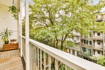 an outside area with trees and plants on the side of a house, taken from a balcony looking out onto...