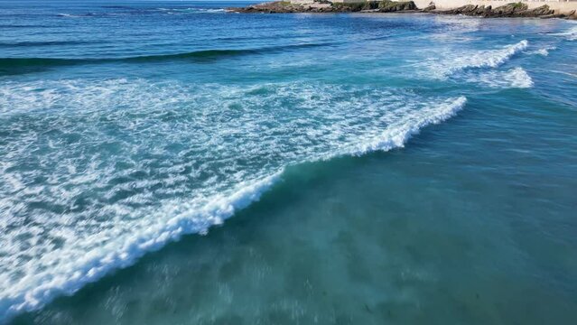 Surfing Waves On The Blue Ocean Of Playa de Caion In Galicia, Spain. Aerial Drone Shot