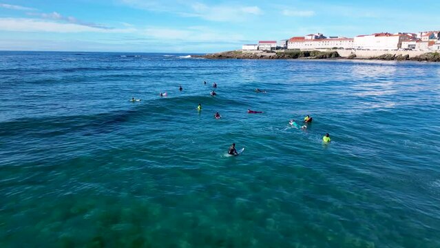Aerial View Of Surfers Swimming And Sitting On Their Surfboards In The Ocean In Caion Beach, Laracha, Spain.