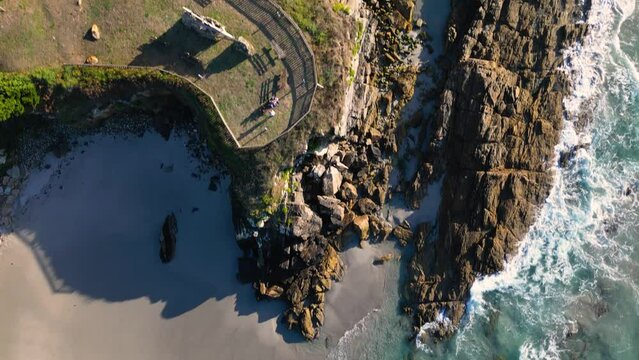 Overhead View Of Sea Waves Crashing On Rocky Coastline Of Beach In Summer In Caion, Galicia, Spain. - aerial