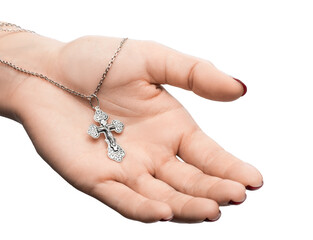 isolated on white background jewelry silver cross on a chain with a shadow lies on the hand of a girl model