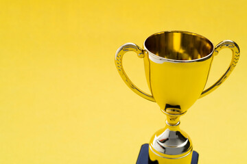 Golden trophy on yellow background
