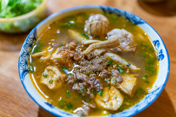 Vietnam traditional street food bun rieu cua crab rice noodle soup bowl with pork foot, blood cake and tofu