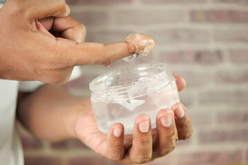 hand hold a jar of hair gel,
