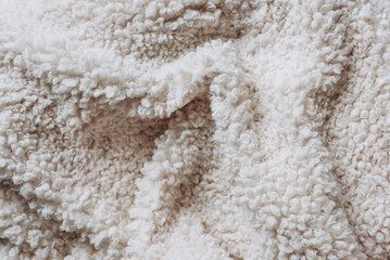 Fototapeta na wymiar Beige curly wool seamless texture background. Warm cozy texture with short factory material.