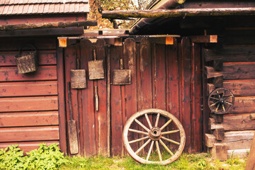Old peasant tools hanging on wooden wall on animal farm.