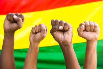 Concept of unity in diversity or equality showing by Group of fist hands rising against the Black history flag