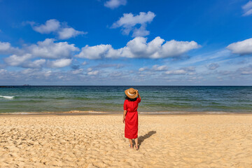 BEAUTIFUL WOMAN IN MAXI DRESS STANDING IN THE KY CO BEACH OF THE SEA, QUY NHON, BINH DINH, VIETNAM