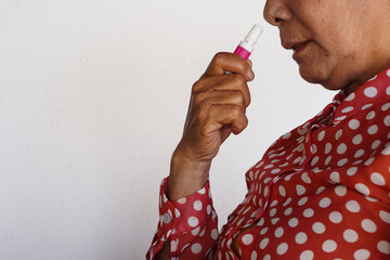 Closeup Asian woman use inhaler to smell  for relieve dizzy or faint symptoms. Concept, health...