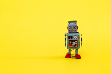 Retro robot toy on yellow background