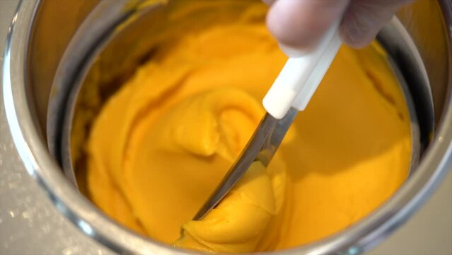 Close-up fotage of yellow mango ice cream, one box of ice cream gelato in a shop.
