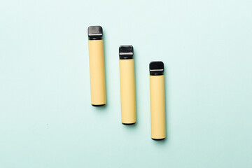 Obraz premium Disposable electronic cigarettes on color background, top view