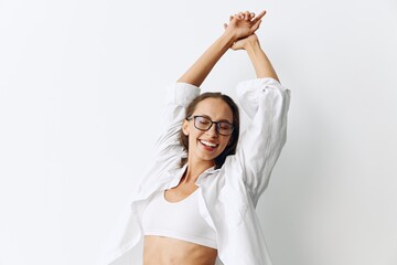 Naklejka premium Happy woman having fun at home in a white top and white shirt with glasses against a white wall, lifestyle
