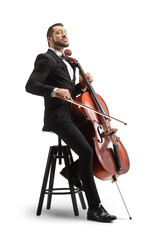 Male musician in a black suit and bow-tie sitting on a chair and playing a cello