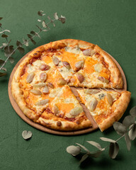 Traditional Italian pizza withpear and gorgonzola cheese. Mediterranean food. Vegetarian dish. Green background. Copy space. Top view.