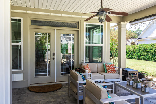 Covered outdoor patio in a new construction house home with guest seating