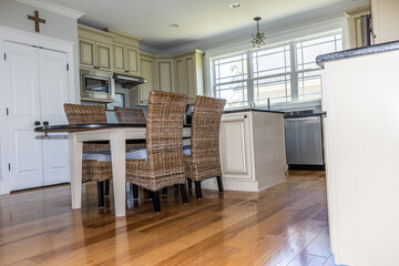 Low angle view of a cream colored new construction kitchen with black granite countertops and wood flooring and stainless steel appliances