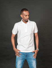 An african man with blank white polo shirt doing a pose while touching his waist on the black...