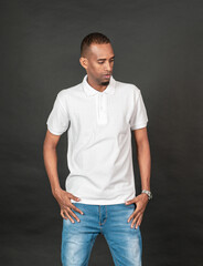 An african man with blank white polo shirt doing a pose while touching his waist on the black background