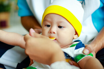 A mother feeds a spoonful of water to her baby son. Mother's day. Family concept.
