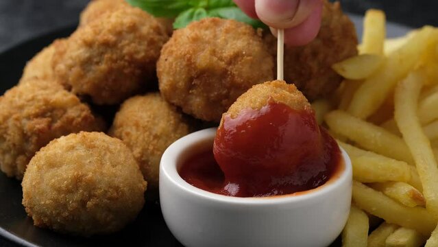 Dipping Mini Chicken kiev breast in ketchup