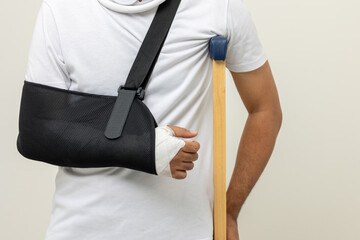 Young man broken arm and leg on isolated. Man put on plaster cast splint with walking sticks...