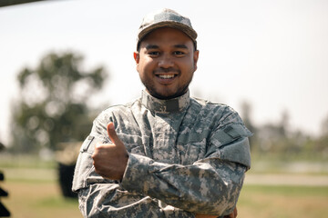 Asian man special forces soldier standing against on the field Mission. Commander Army soldier military defender of the nation in uniform standing near battle tank while state of war.