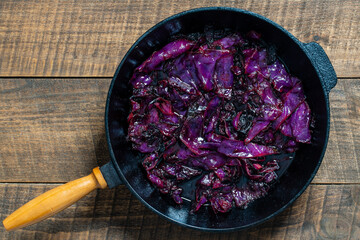 Red cabbage are pan-fried until lightly charred, then braised in mulled wine. Background of fry blue cabbage in a section, macro. Closeup, top view. Texture and pattern of purple cabbage