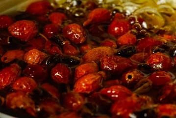 fresh vitamin rose hips are brewed in water. vitamin rosehip tea is boiled on the stove