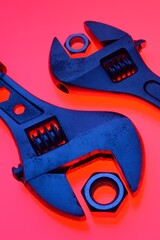 adjustable wrench and nuts of different sizes on a red background.Close-up