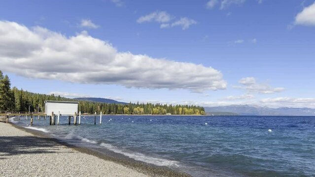 Clouds passing over  a deserted pepple beach on Lake Tahoe on a sunny autumn day. California, USA -  Time lapse.