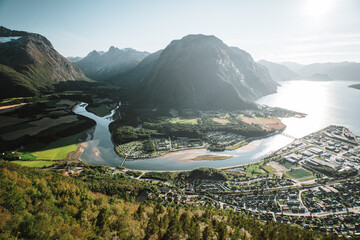 Beautiful view from the top of a mountain of a valley with a small town, a beautiful fjord and...