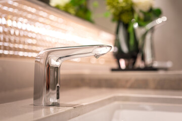 A luxury automatic hand washing faucet with background of . Interior equipment object photo,...
