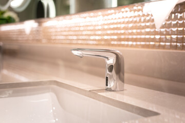 A luxury automatic hand washing faucet with background of . Interior equipment object photo,...