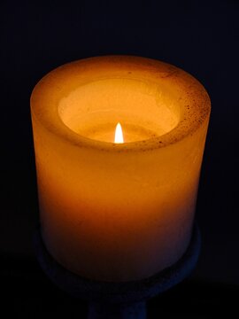 Helle Kerze vor einem dunklen Hintergrund