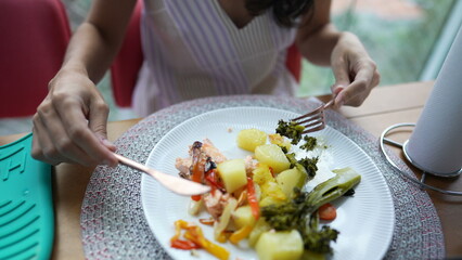 Woman eating healthy food on plate. Person eats vegetables organic meal for lunch time