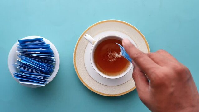 pouring Sugar Substitute sweetener in a cup of tea 