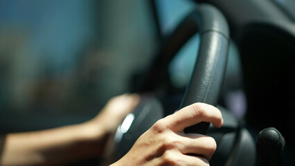 Closeup of person hands on steering wheel driving car. Woman driving a vehicle. Slow-motion driving...