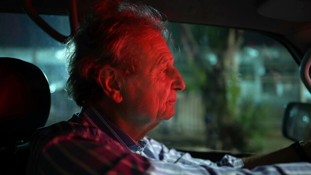 Older Man Driving At Night In City. Profile Closeup Face Of Mature Senior Male Driver Person Drives In Evening