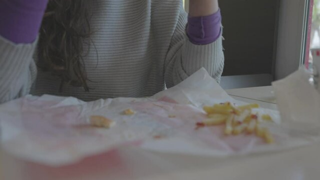 Mujer comiendo hamburguesa en restaurante comida r&aacute;pida (Formato LOG para edici&oacute;n y correcci&oacute;n de color profesional)
