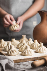 Girl cooking khinkali, traditional Georgian dish, selective focus