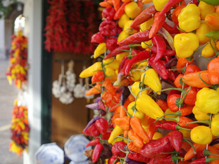 Palma de Mallorca, Spain - 7 Nov, 2022: Strings of red and yellow  chilli peppers hanging in a grocery store