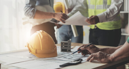 Civil engineer teams meeting working together wear worker helmets hardhat on construction site in modern city. Foreman industry project manager engineer teamwork. Asian industry professional team.