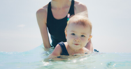 Fototapeta na wymiar Woman swims in the sea with kid