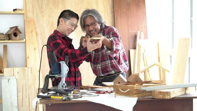 Asian pre-teen boy help grandfather work woodwork, teenager boy taking measure making toys or wooden craft, carpentry father training, teaching son using instruments, fatherhood or family relationship