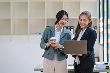 Two Asian businesswomen discussing a startup project concept presentation Analysis of planning and financial statistics and investment markets at office.