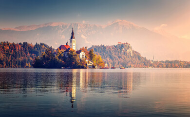 Scenic image of Fairytale lake Bled during pinc sunset. Natural summer scenery with colorful sky....